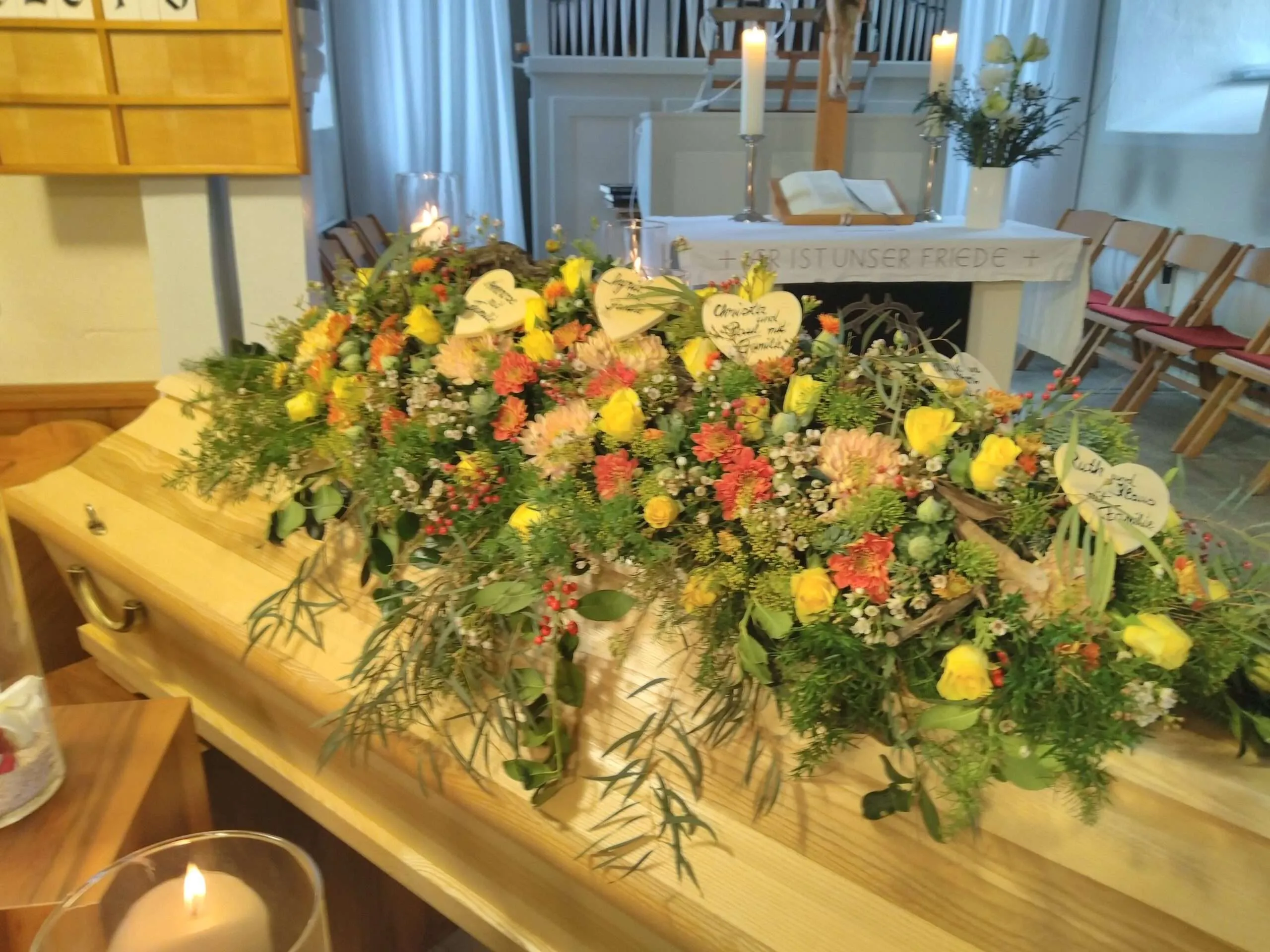 Sarg mit Blumenschmuck in einer Trauerhalle